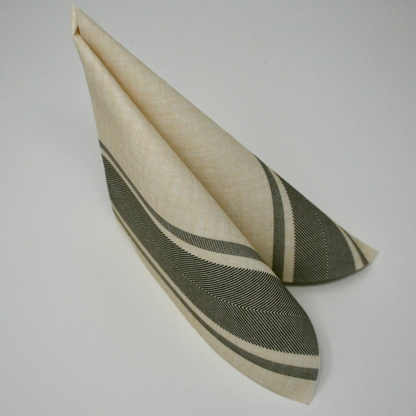 Hochwertige beige Airlaid-Serviette mit elegantem grauen Streifenmuster, stehend zum Dreieck gefaltet für die Tischdekoration