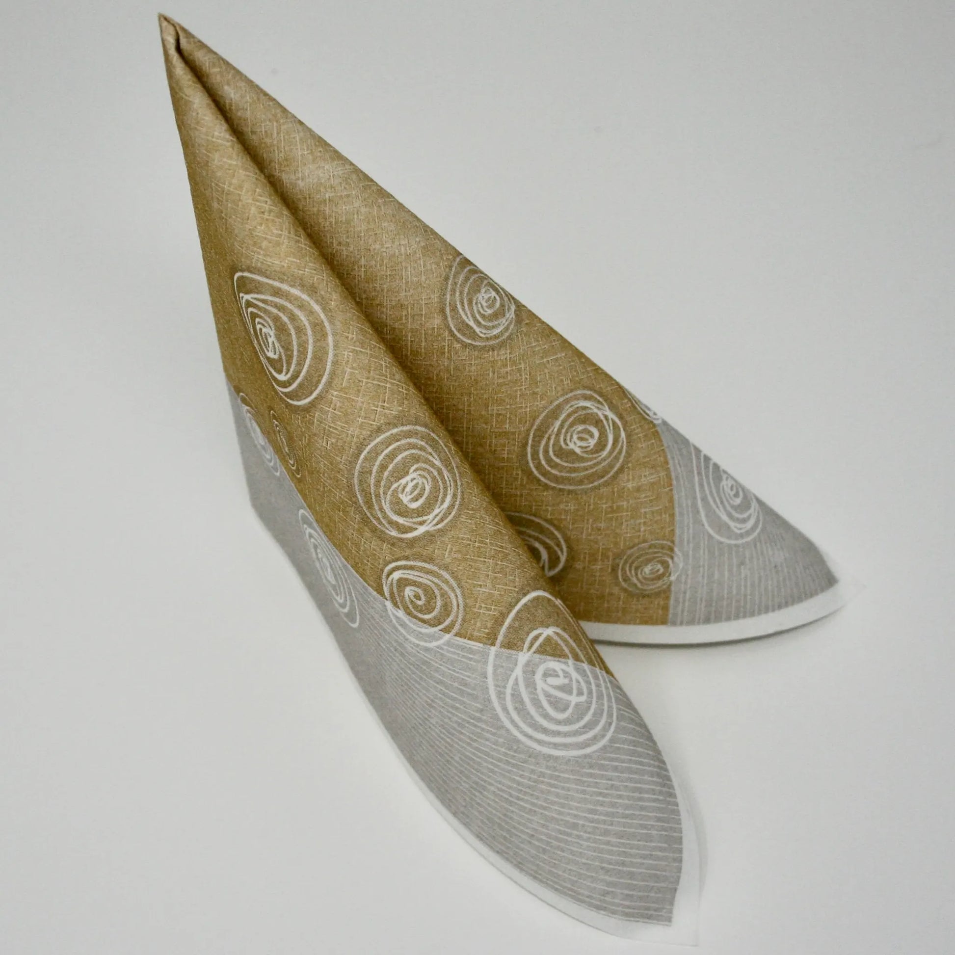 Moderne Airlaid-Serviette in Ocker, Grau und Weiß mit verspieltem Kreis-Muster, stehend zum Dreieck gefaltet für die Tischdekoration